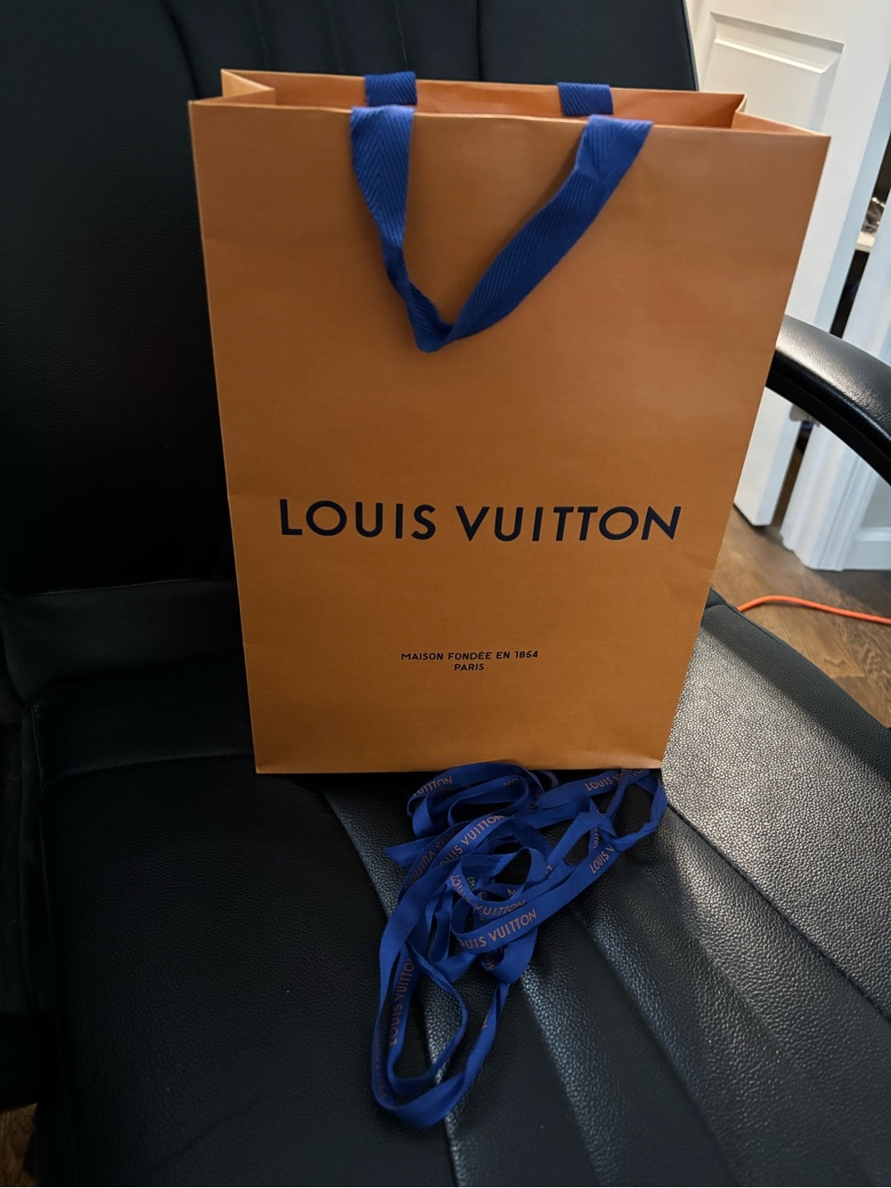 Authentic Louis Vuitton orange shopping bag with blue ribbon handles